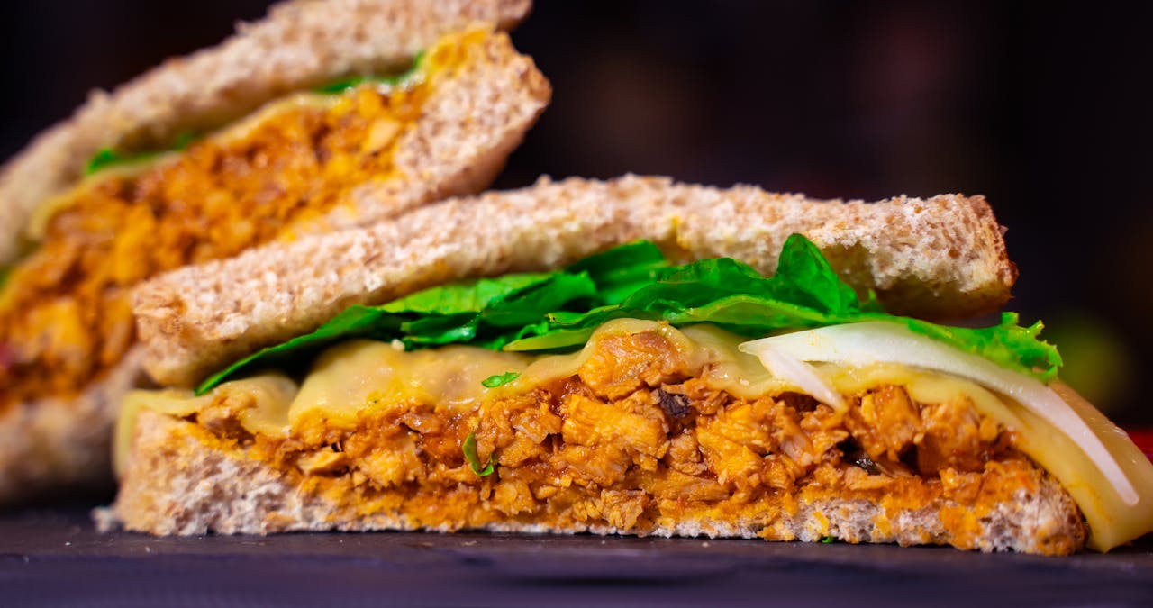 Close-up of a flavorful Mexican-style chicken sandwich with vegetables.